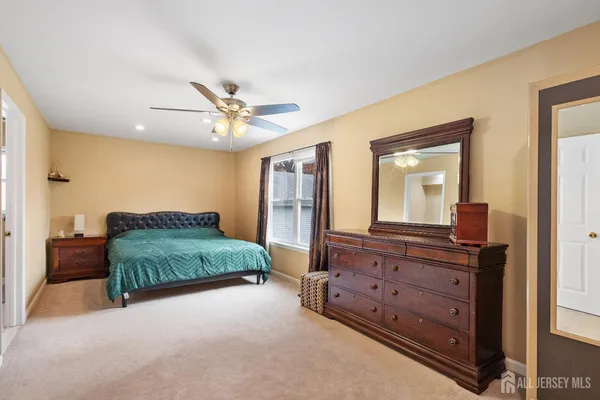 a bedroom with a bed and a dresser with mirror