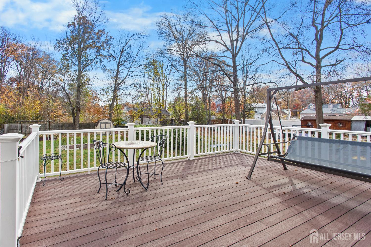 1740 Holly Road North Brunswick, NJ 08902 - Photo 26 of 32 a view of a deck with a chair and table and chairs on wooden floor