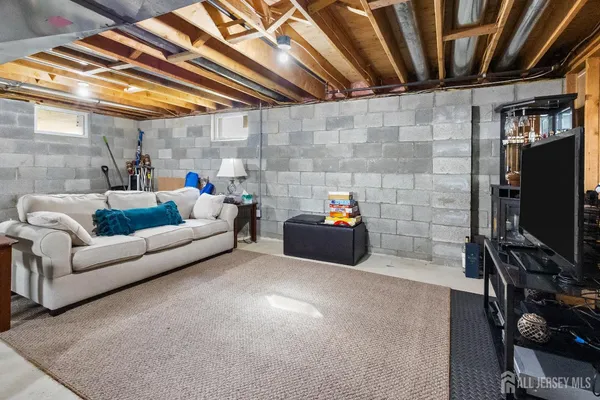 a living room with furniture a flat screen tv and gym equipment
