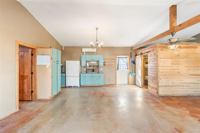 a view of a kitchen with refrigerator and a sink