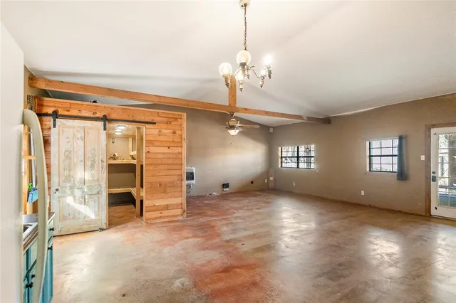a view of a livingroom with a furniture ceiling fan and window