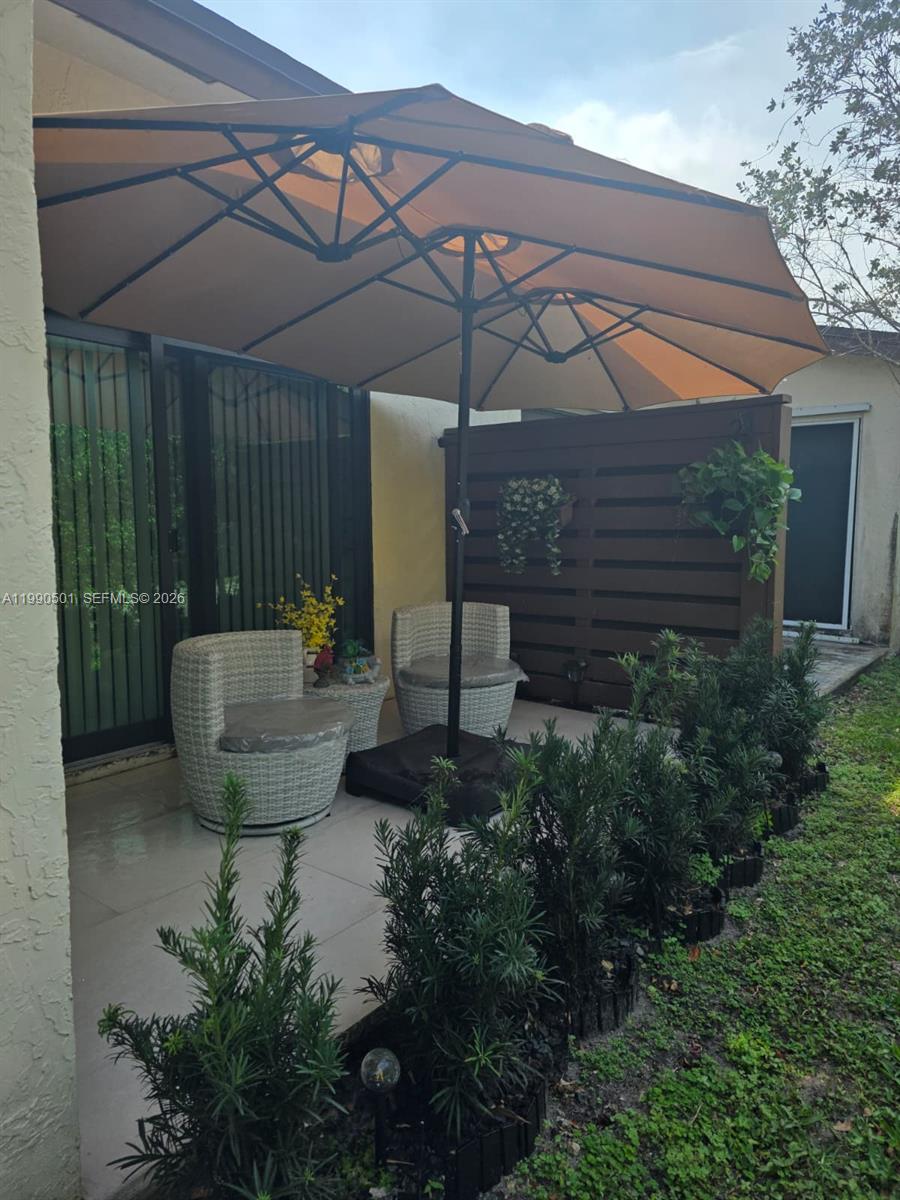 893 Southwest 120th Way Davie, FL 33325 - Photo 20 of 22 a view of a chairs and table in patio with potted plants