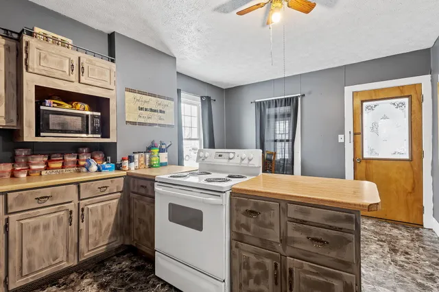 a kitchen that has a sink a stove and a wooden floor