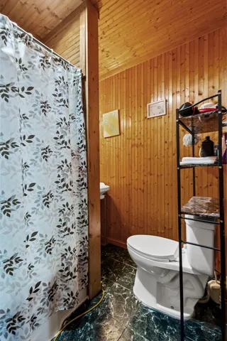 a bathroom with a toilet and a shower curtain