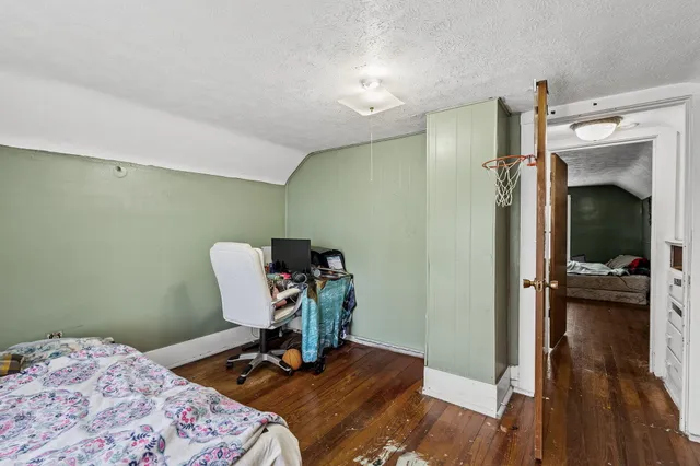 a bedroom with a bed and wooden floor