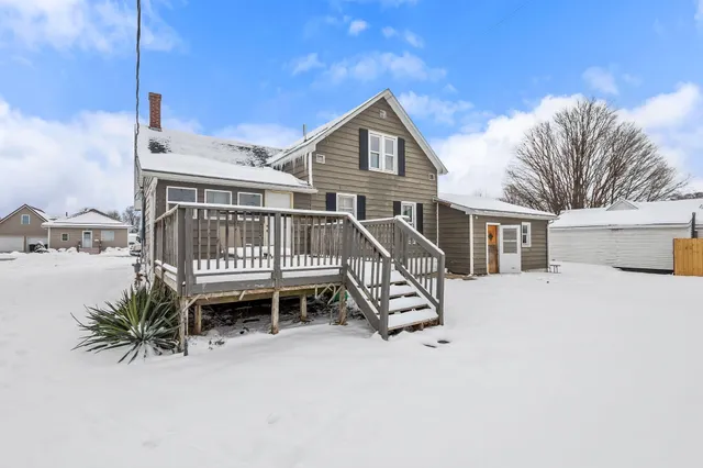 a view of a house with wooden deck and a wooden fence