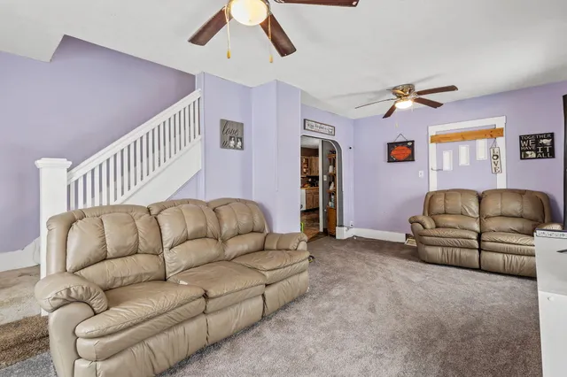 a living room with furniture and a ceiling fan