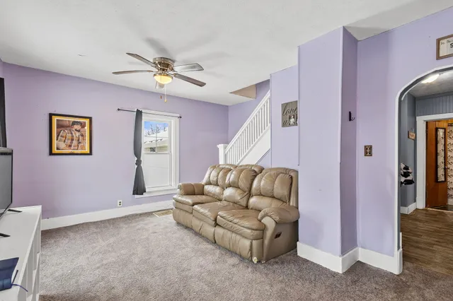 a living room with furniture and a ceiling fan