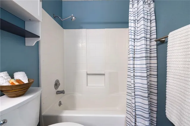 an empty room with wooden floor chandelier fan and windows