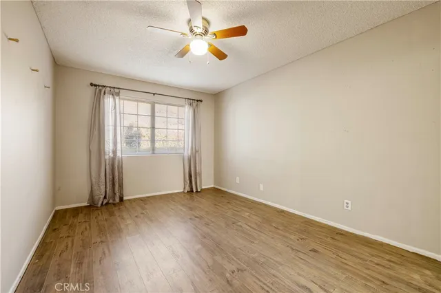 an empty room with closet and a chandelier fan