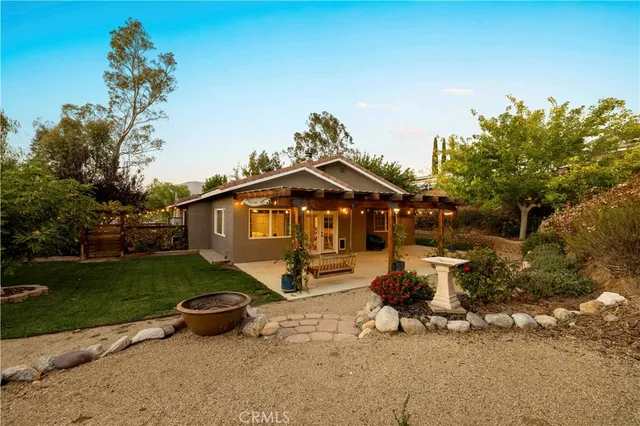 a backyard of a house with barbeque oven table and chairs
