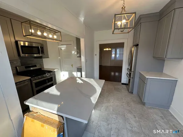 a large kitchen with a sink a refrigerator and a stove top oven