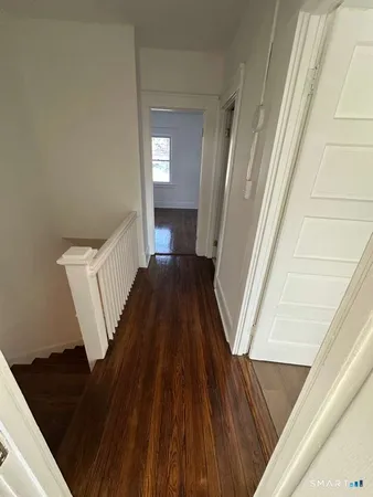 a view of a hallway view with wooden floor and staircase