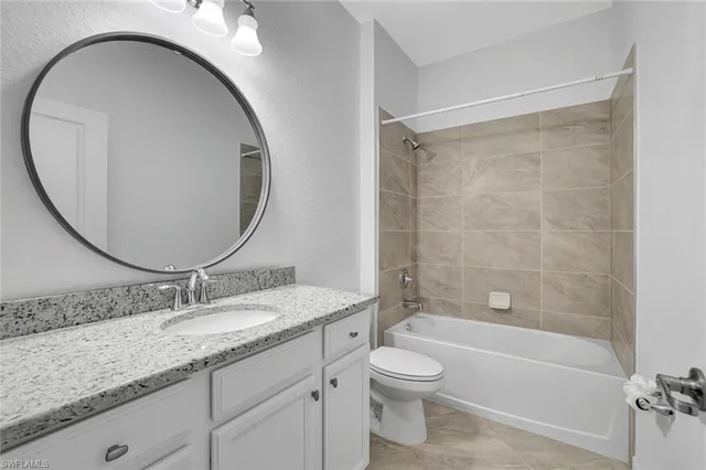 a bathroom with a granite countertop toilet a sink and a mirror