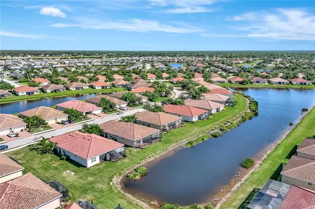 an aerial view of residential houses with outdoor space and lake view
