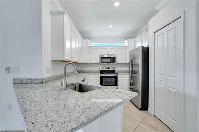 a kitchen with stainless steel appliances granite countertop a sink refrigerator and microwave