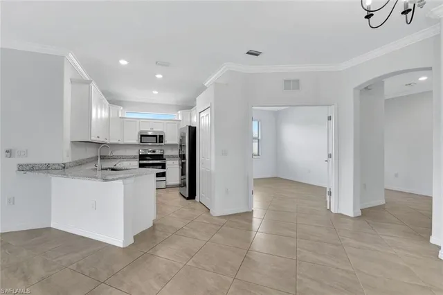 a kitchen with stainless steel appliances kitchen island sink refrigerator and cabinets