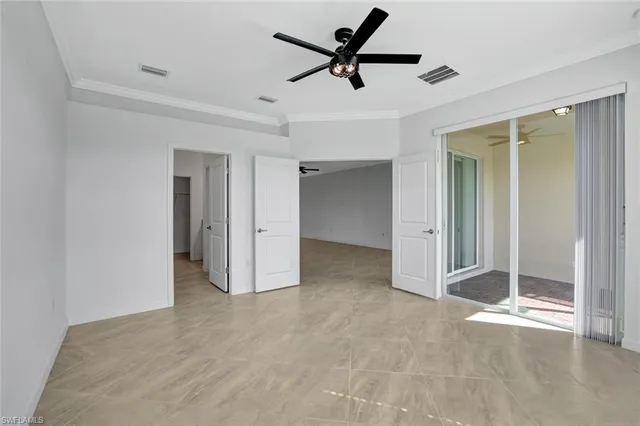 a view of empty room with wooden floor and ceiling fan