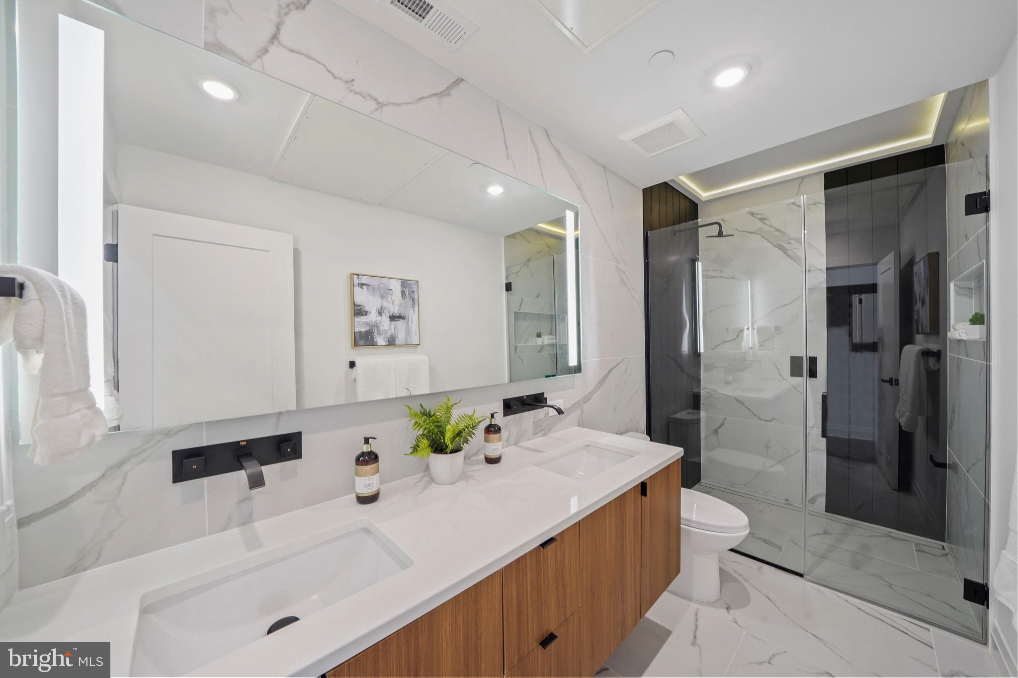 a spacious bathroom with a granite countertop sink a toilet and shower