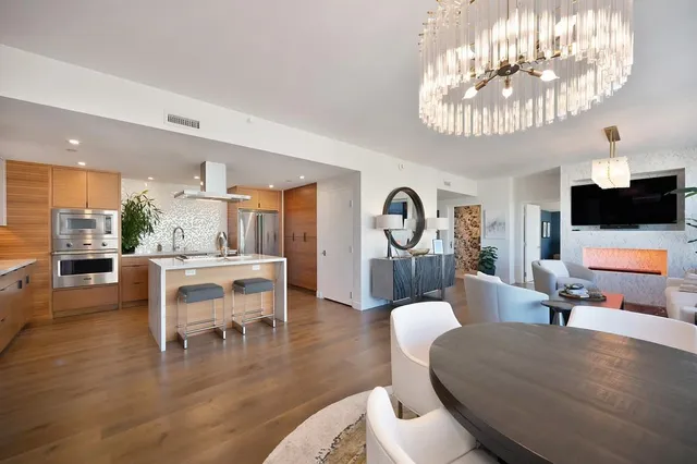 a view of a dining room with furniture a chandelier and window