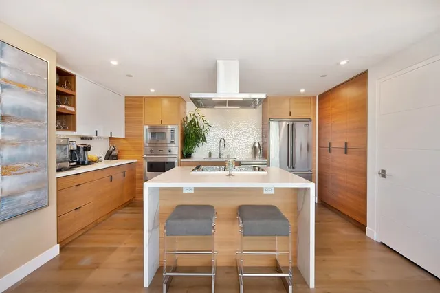 a kitchen with stainless steel appliances kitchen island a stove a sink and a refrigerator