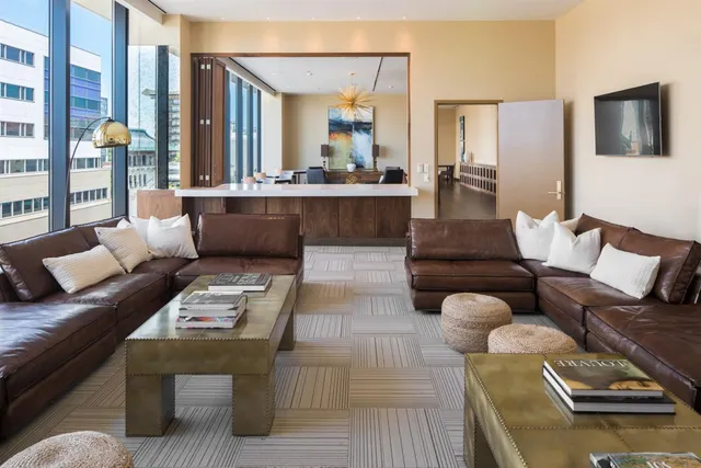 a living room with lots of furniture and a floor to ceiling window