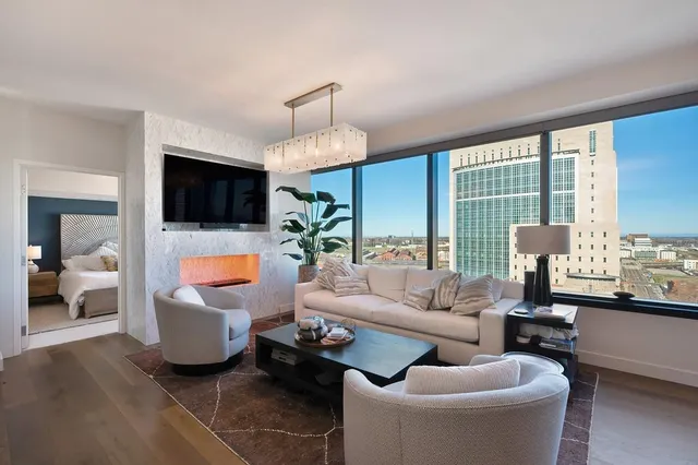a living room with furniture flat screen tv and a large window