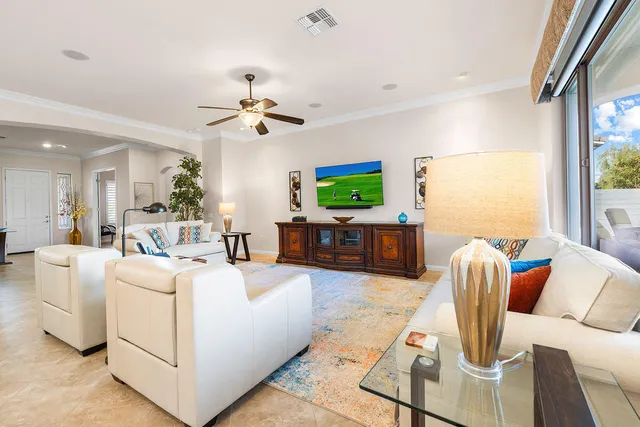 a living room with furniture a flat screen tv and a large window