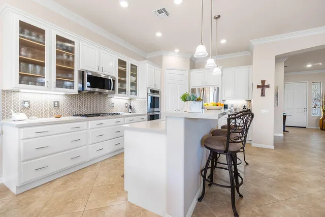 a kitchen with stainless steel appliances kitchen island granite countertop a stove a sink and a refrigerator