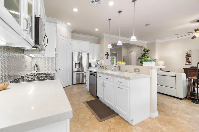 a kitchen with a white wooden cabinets stove and a sink