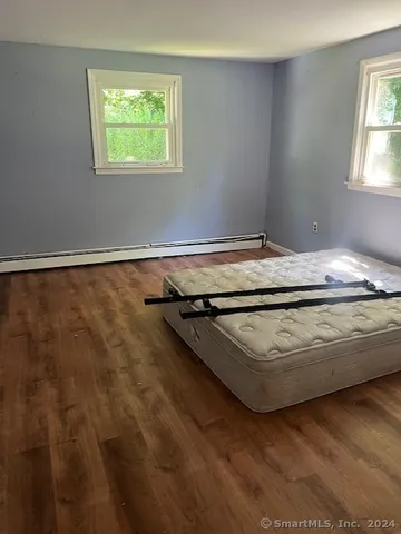 a bed sitting in a bedroom next to a window