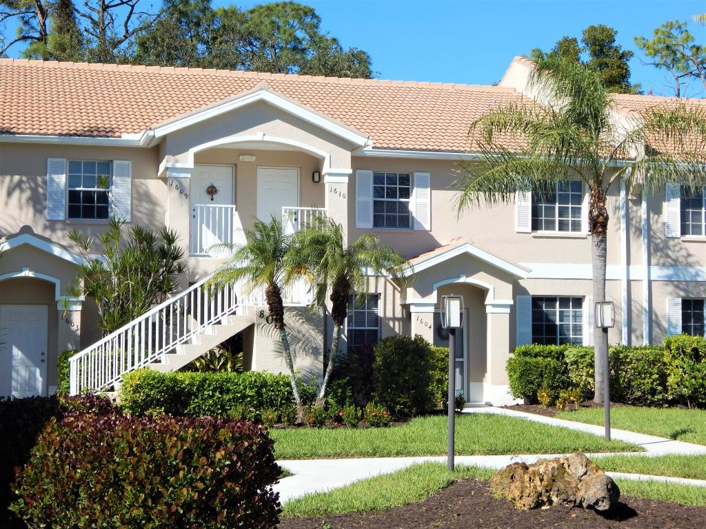8065 Tiger Cove, Unit 1610 Naples, FL 34113 - Photo 1 of 11 a front view of a house with a yard