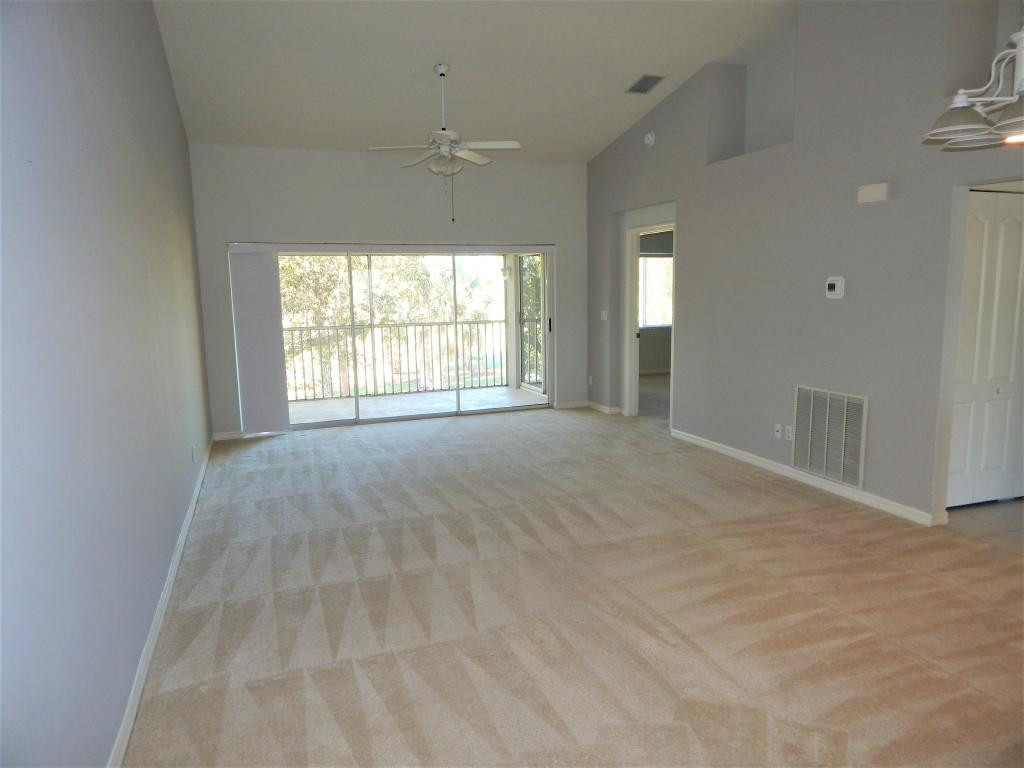 8065 Tiger Cove, Unit 1610 Naples, FL 34113 - Photo 3 of 11 an empty room with large windows