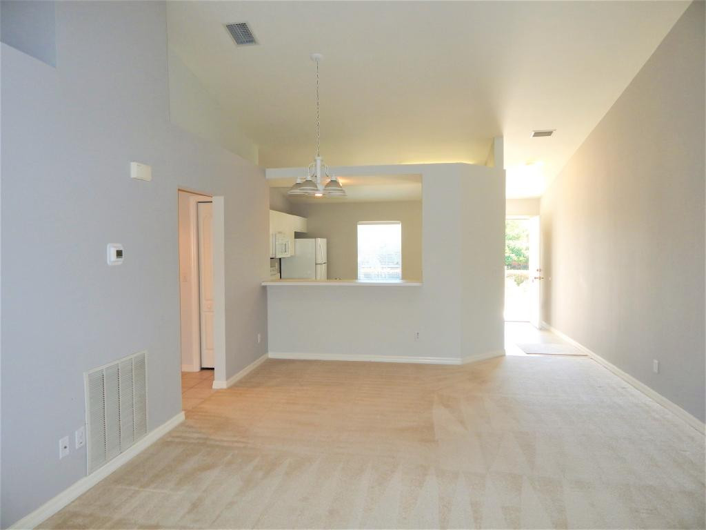 8065 Tiger Cove, Unit 1610 Naples, FL 34113 - Photo 6 of 11 a view of an empty room with wooden floor and a window