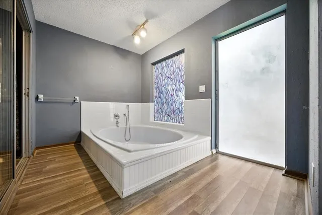 an empty room with windows and fan