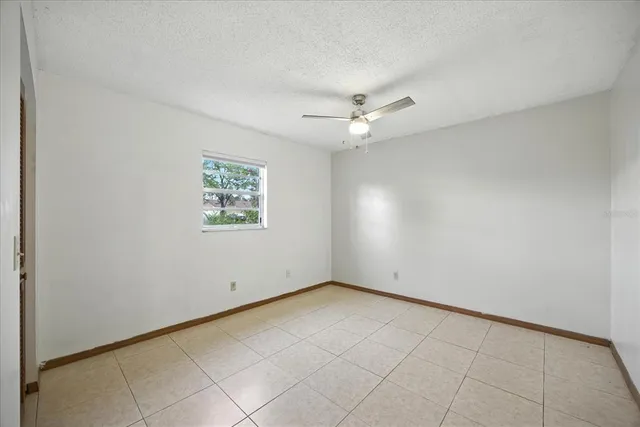 an empty room with chandelier fan
