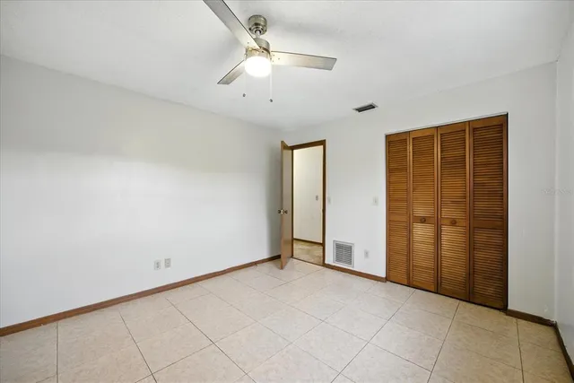 an empty room with windows and fan