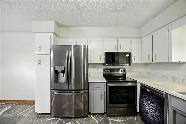 a kitchen with cabinets and stainless steel appliances