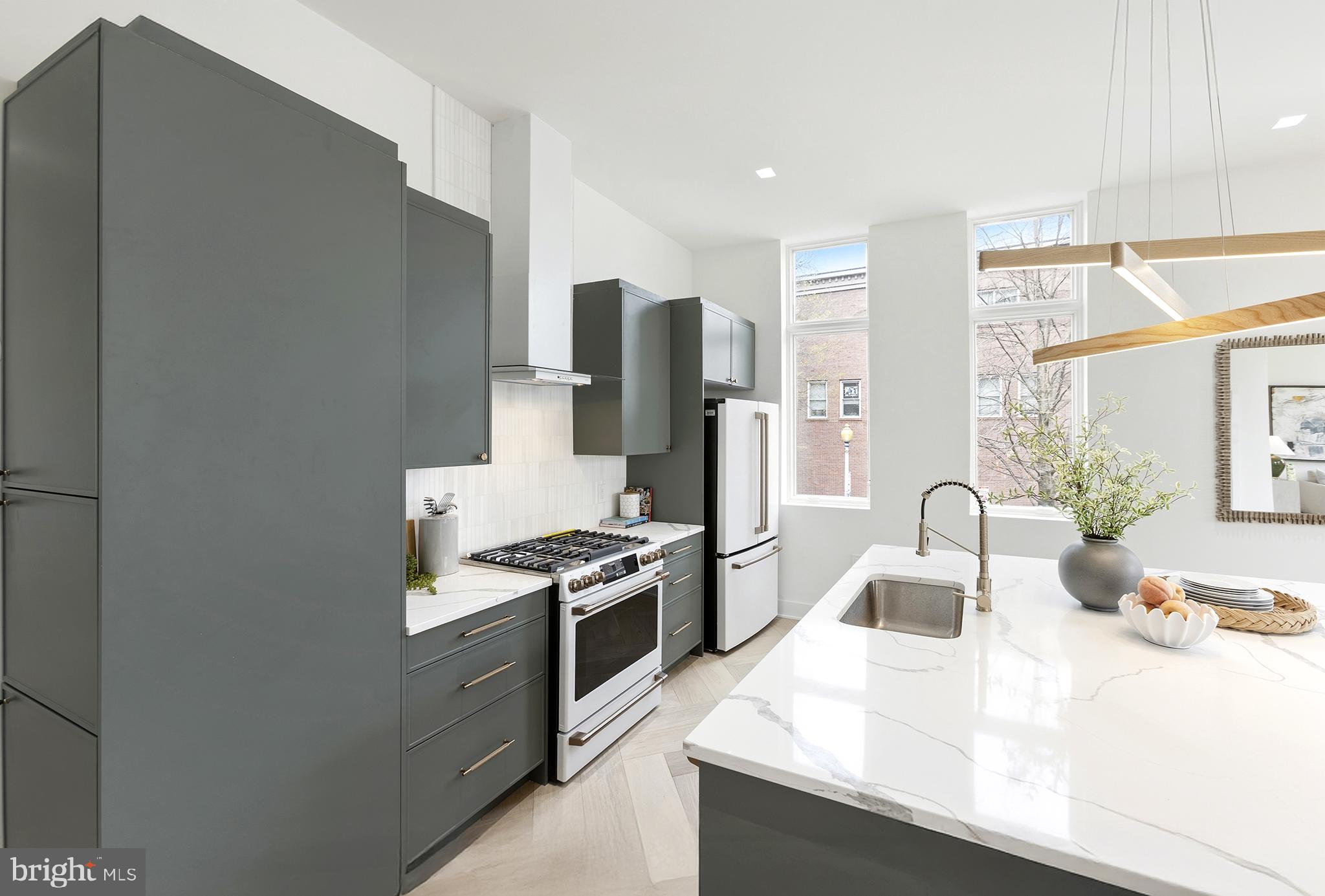 1212 4th Street Northwest, Unit 9 Washington, DC 20001 - Photo 13 of 42 a kitchen with stainless steel appliances granite countertop a sink stove and refrigerator