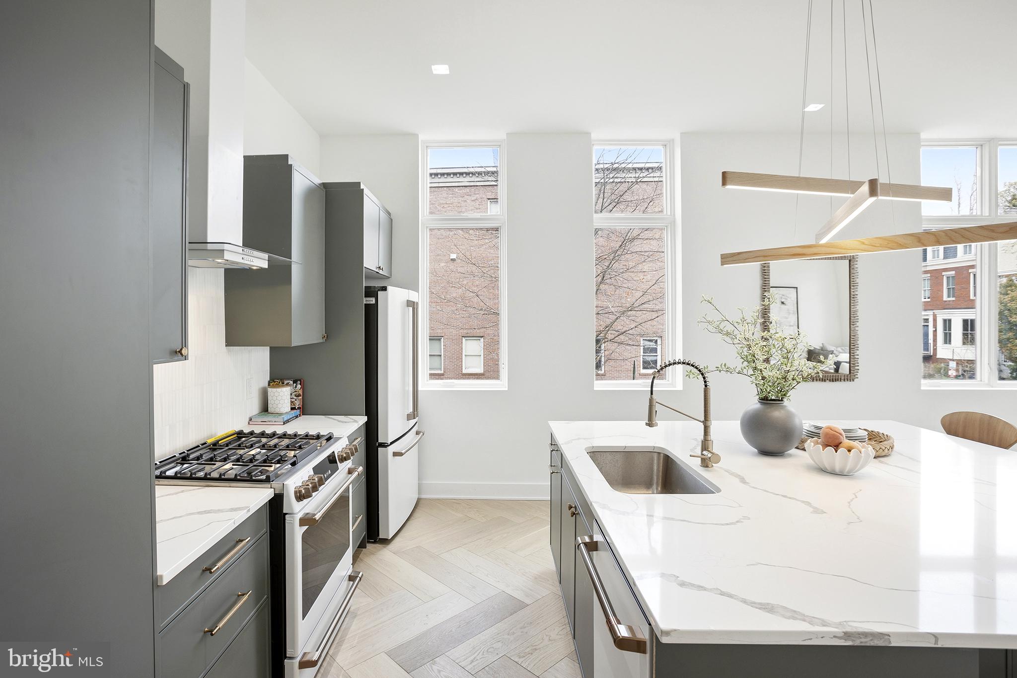 1212 4th Street Northwest, Unit 9 Washington, DC 20001 - Photo 14 of 42 a kitchen with stainless steel appliances kitchen island granite countertop a sink stove and refrigerator
