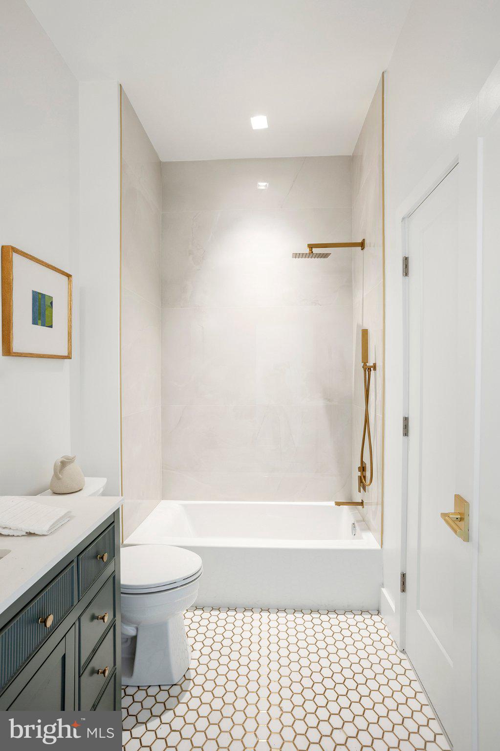 1212 4th Street Northwest, Unit 9 Washington, DC 20001 - Photo 20 of 42 a bathroom with a bathtub shower sink vanity and a toilet