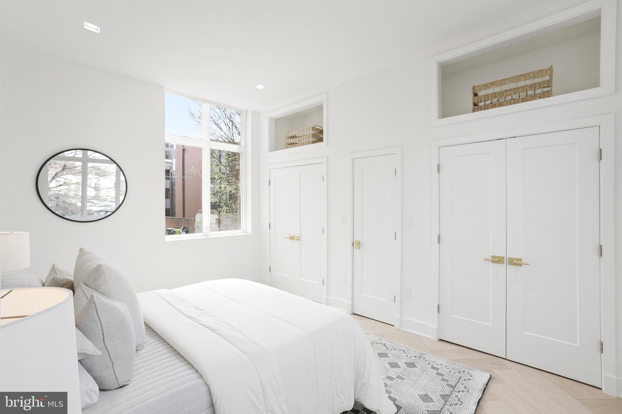 1212 4th Street Northwest, Unit 9 Washington, DC 20001 - Photo 27 of 42 a bedroom with a bed a mirror and a table