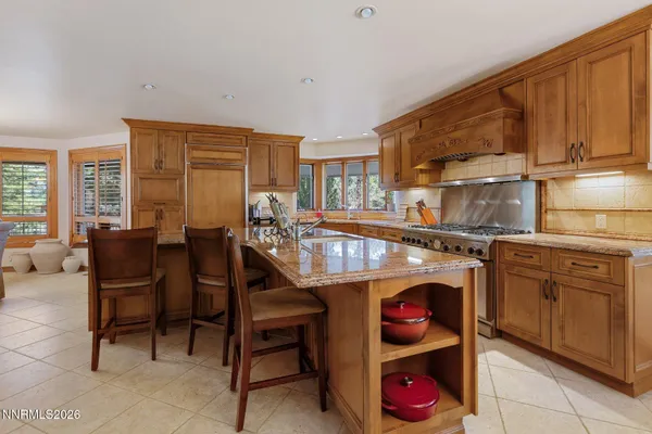 a dining hall with stainless steel appliances granite countertop a stove and a dining table view