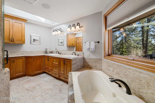 a view of a backyard with table and chairs potted plants and a large tree