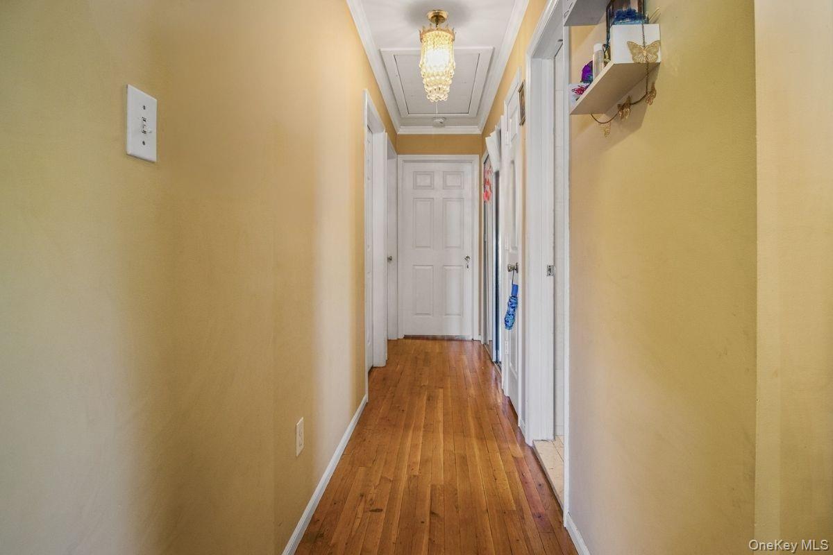 135-06 62nd Road Queens, NY 11367 - Photo 15 of 20 a view of a hallway with wooden floor and a bathroom