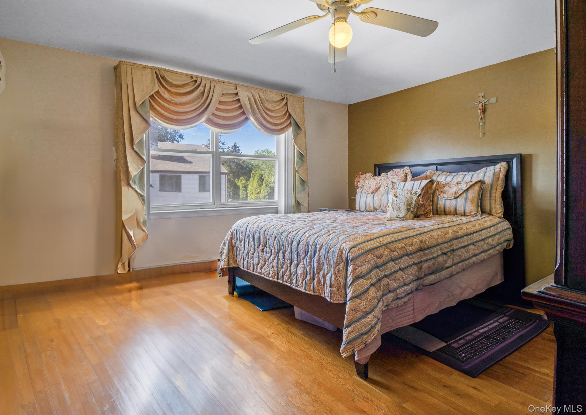 135-06 62nd Road Queens, NY 11367 - Photo 9 of 20 a bedroom with a bed and a window