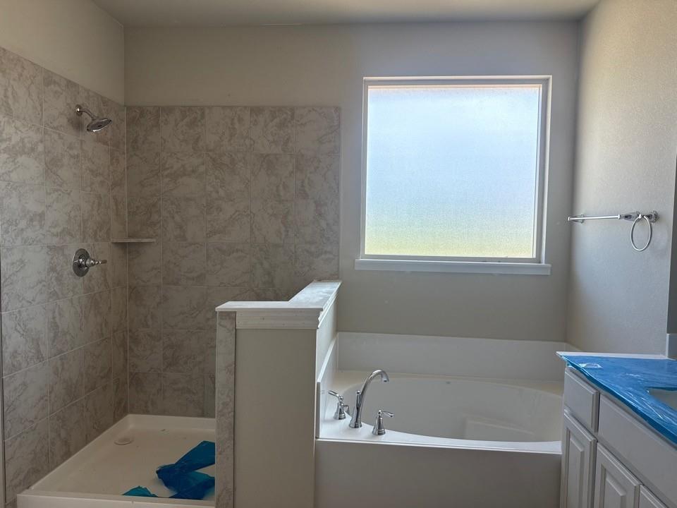 1228 Colca Drive Springtown, TX 76082 - Photo 9 of 9 Bathroom featuring a large soaking tub, separate shower with tiled surround, and a frosted window