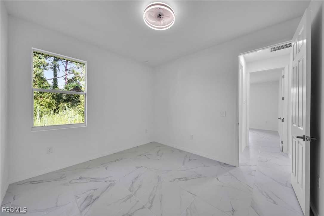 312 Harrison Drive Lehigh Acres, FL 33936 - Photo 14 of 17 an empty room with windows