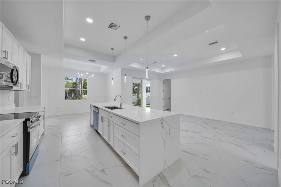 312 Harrison Drive Lehigh Acres, FL 33936 - Photo 4 of 17 a large white kitchen with a large window
