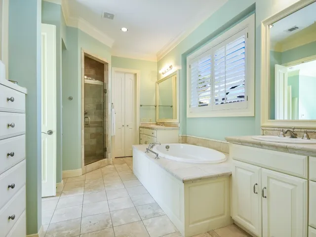 a spacious bathroom with a granite countertop sink a mirror a bathtub and shower